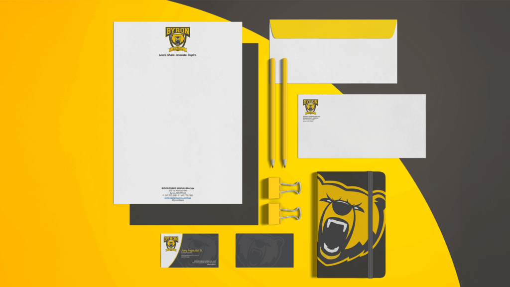 Mockups of new logo and branding on items like notebooks and other writing tools.