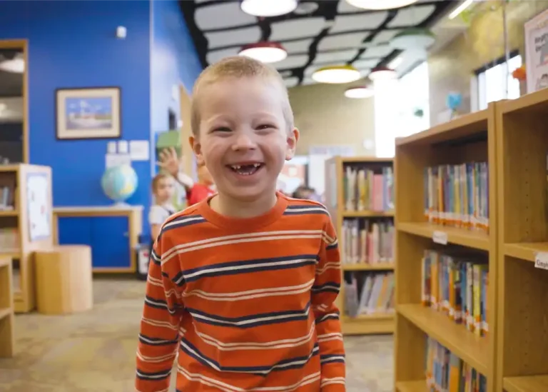 Young student smiling in a library.