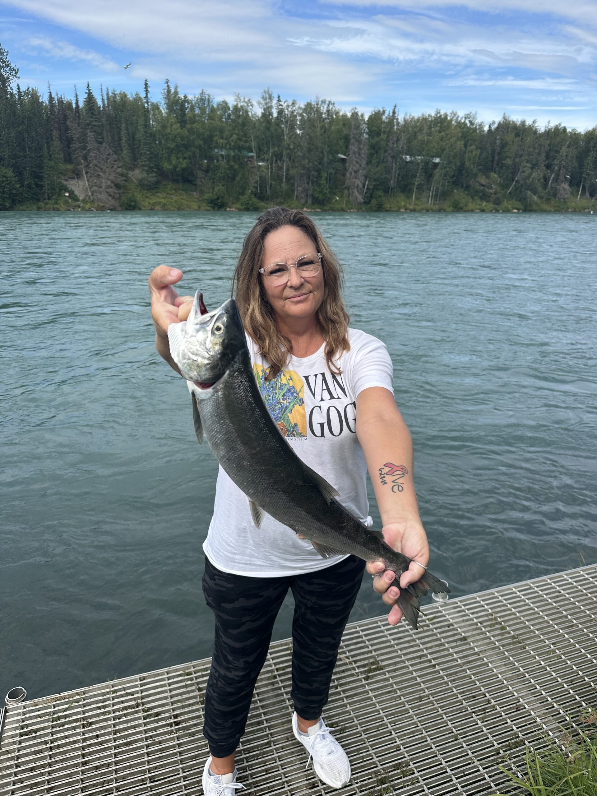 Julie Miller holding a large fish on a dock